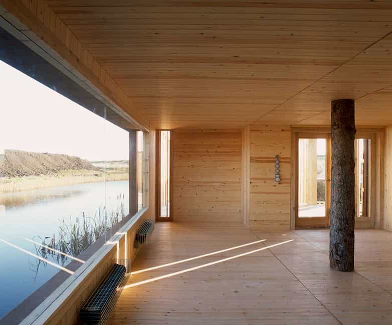 Inside the walls are lined with larch boards. The large windows look out over the water towards the open marshland.